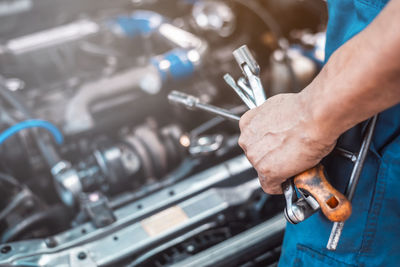 Midsection of man working on car