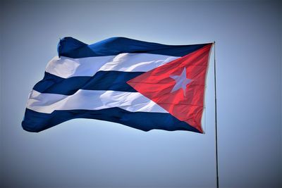 Low angle view of flag against blue sky