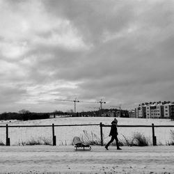 Side view of person walking with sledge