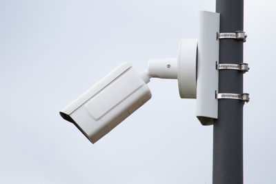 A surveillance camera on a pillar of a modern building.video surveillance, security.