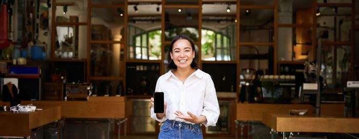 Portrait of young woman standing in library