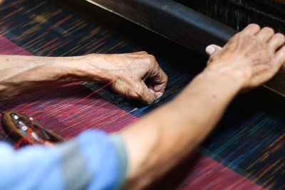 Cropped hands weaving loom