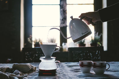 Coffee cup on table against window