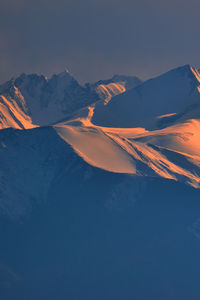 Scenic view of snowcapped mountains against sky during sunset