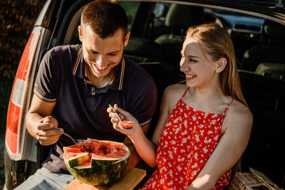 Local travel, romantic picnic date ideas. couple in love on summer picnic with watermelon in car