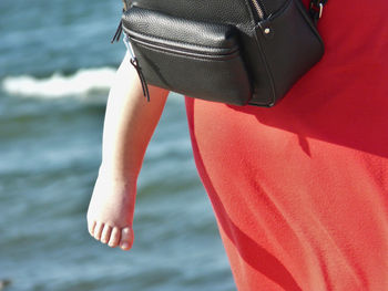 Low section of woman on sea shore