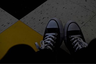 Low section of man standing on tiled floor