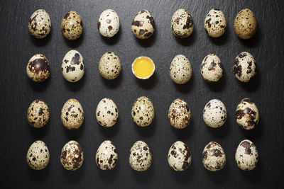 Quail eggs on a black table.