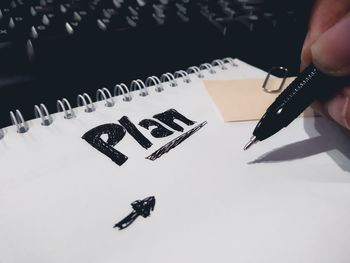 Close-up of hand holding paper with text