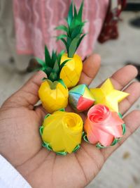 Close-up of hand holding multi colored rose