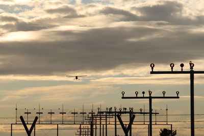 Plane flying against sky during sunset