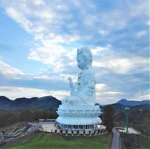 Statue of buddha against cloudy sky