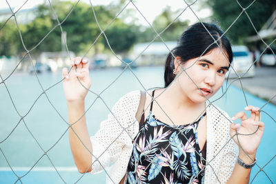 Portrait of woman seen through net in court