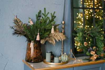 Christmas decor in the living room interior, christmas tree branches, candles on the blue chest