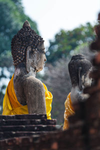 Statue of angel outside temple against building