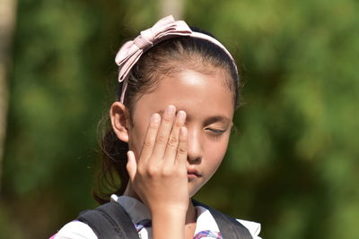 Cute girl closing eyes outdoors