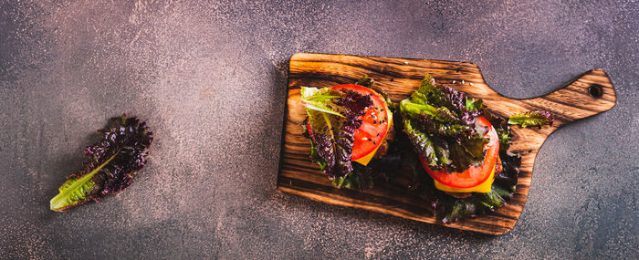 Juicy keto burgers on fresh lettuce leaves of cutlet, tomato and cheese top view web banner