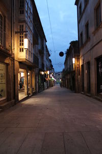 Empty road in city against sky