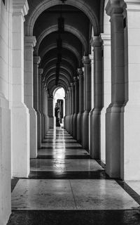 Rear view of man walking in corridor of building