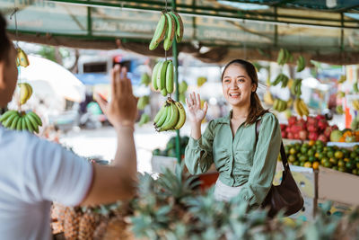 Portrait of young woman standing at market