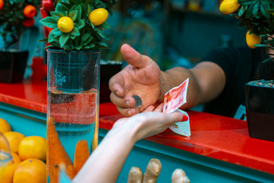 Midsection of person holding drink on table