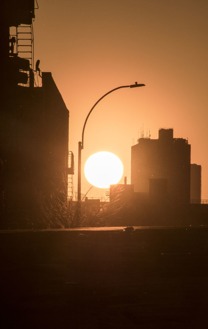 SILHOUETTE BUILDINGS AGAINST SKY AT SUNSET