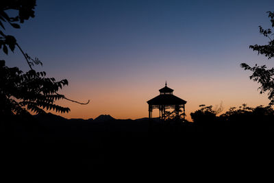 Silhouette built structure against sky during sunset