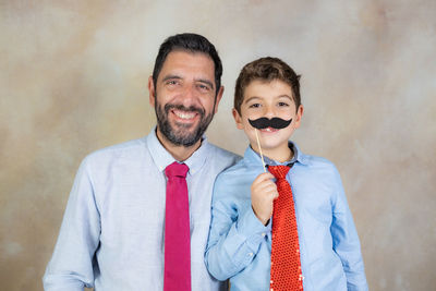 Funny kid with moustache and his father on fathers day