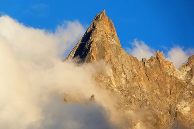 Low angle view of volcanic mountain against sky