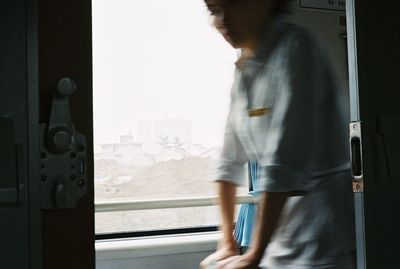 Woman standing by window