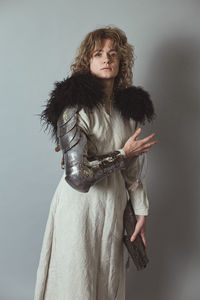 Lady knight with metal glove in antique clothes in studio portrait picture