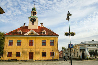 Street by buildings against sky in city