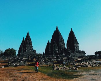 People at temple against clear sky