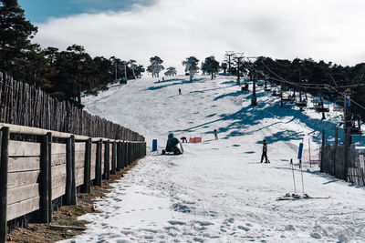 People skiing on snowcapped mountain against sky