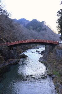 Arch bridge over river against sky