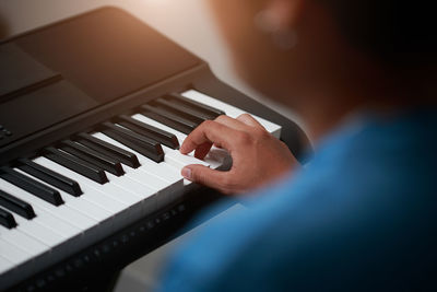 Cropped hand of woman playing piano