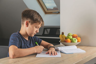 Boy sitting on table at home