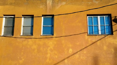 Low angle view of windows on yellow building