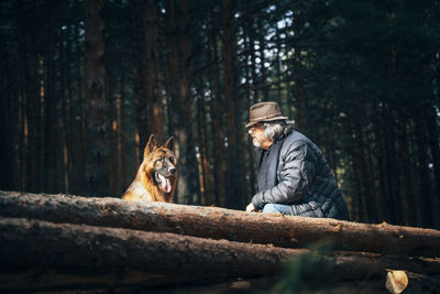 Man sitting by tree in forest