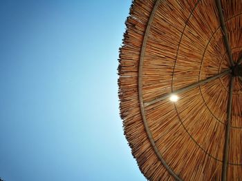 Low angle view of illuminated lamp against clear blue sky