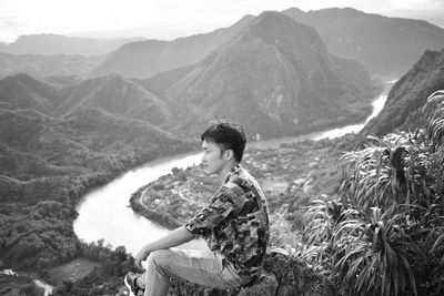 Side view of young man looking at mountains
