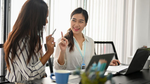 Businesswoman using laptop while sitting at office