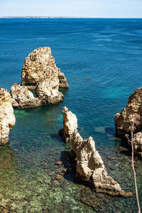 Rock formation in sea against sky