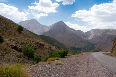 Road by mountains against sky