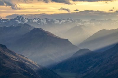 Scenic view of snowcapped mountains against sky during sunset