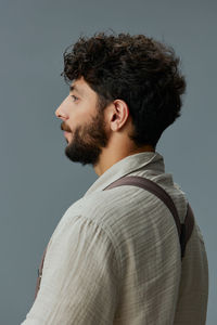 Side view of young man standing against clear sky