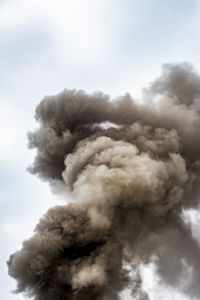 Low angle view of smoke emitting from against sky