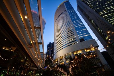 Low angle view of illuminated buildings against sky at night
