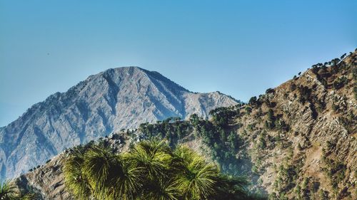 Low angle view of mountains against clear blue sky