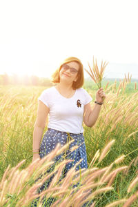 Woman holding plants on field